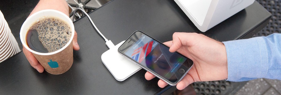 An iPhone paying wirelessly with a Square device.